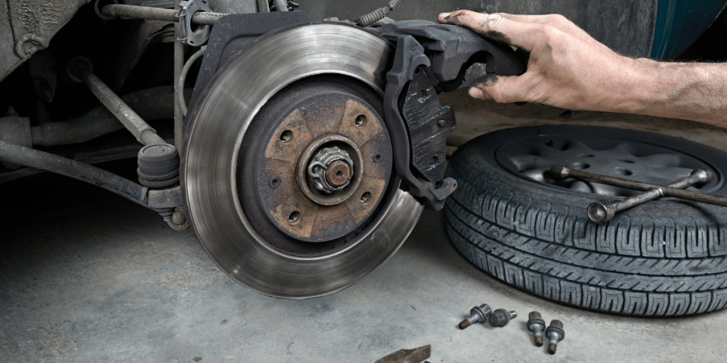 A picture of a car with the hood up, showing the brake pads and rotors.